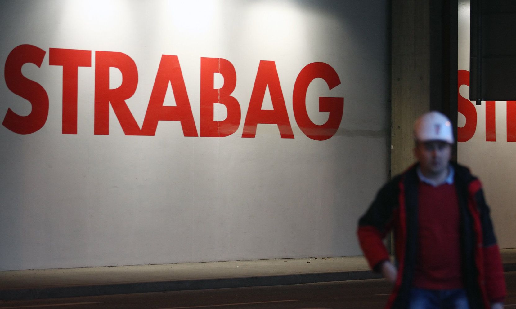 A worker walks past the logo of Austrian construction firm Strabag at its headquarters in Vienna